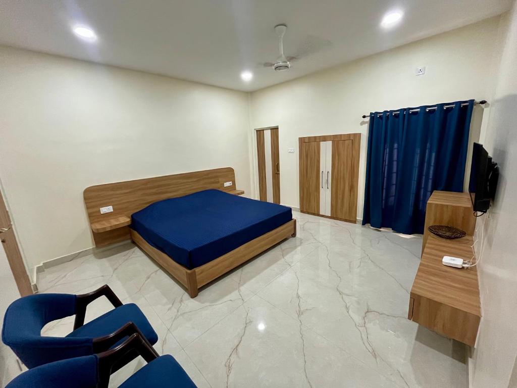 1 dormitorio con 1 cama azul y sillas azules en ClubGreens, en Jorhat