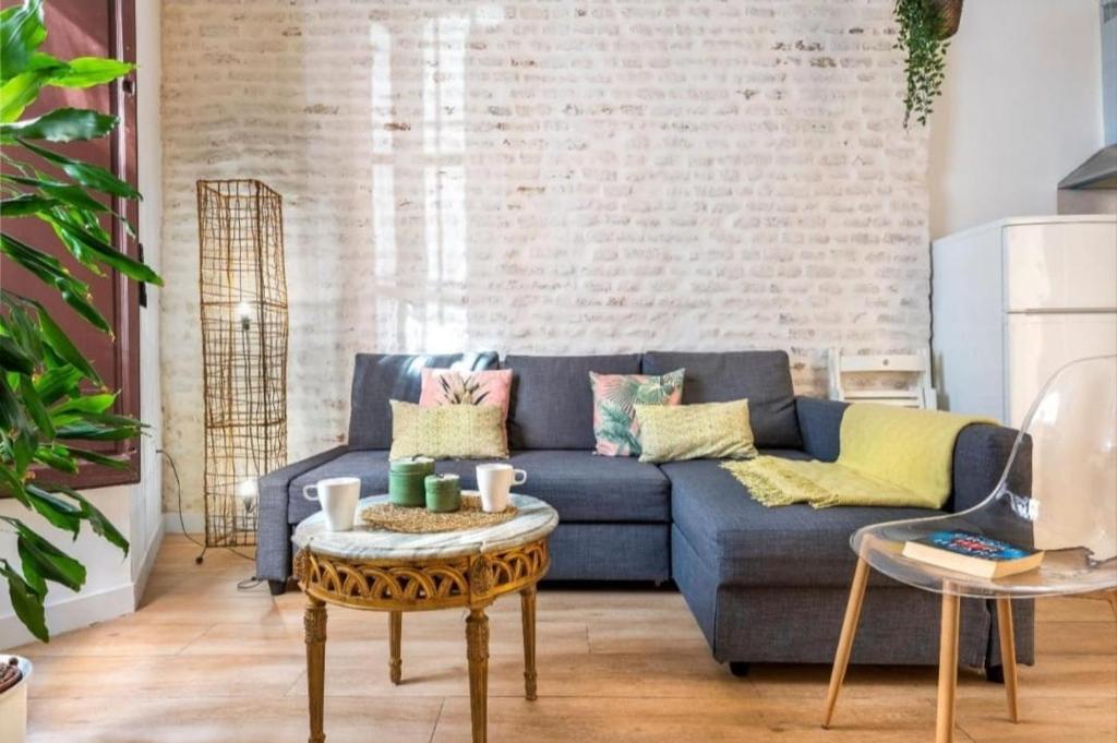 a living room with a blue couch and a table at Bajo Gerona in Seville