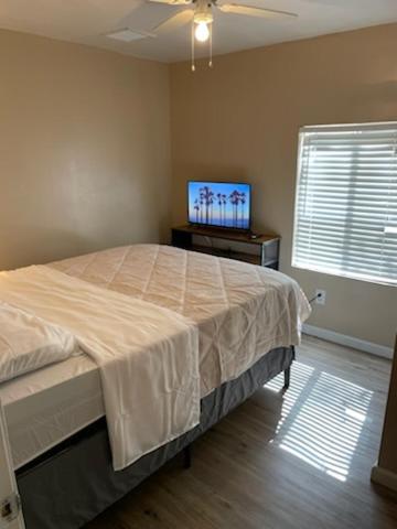 a bedroom with a bed and a flat screen tv at PRIVATE ROOM IN DOWNTOWN FULL KITCHEN and BATHROOM shared ARTS RooSEVELT ROW CONVENTION CENTER STADIUMS ASU DOWNTOWN PHOENIX in Phoenix