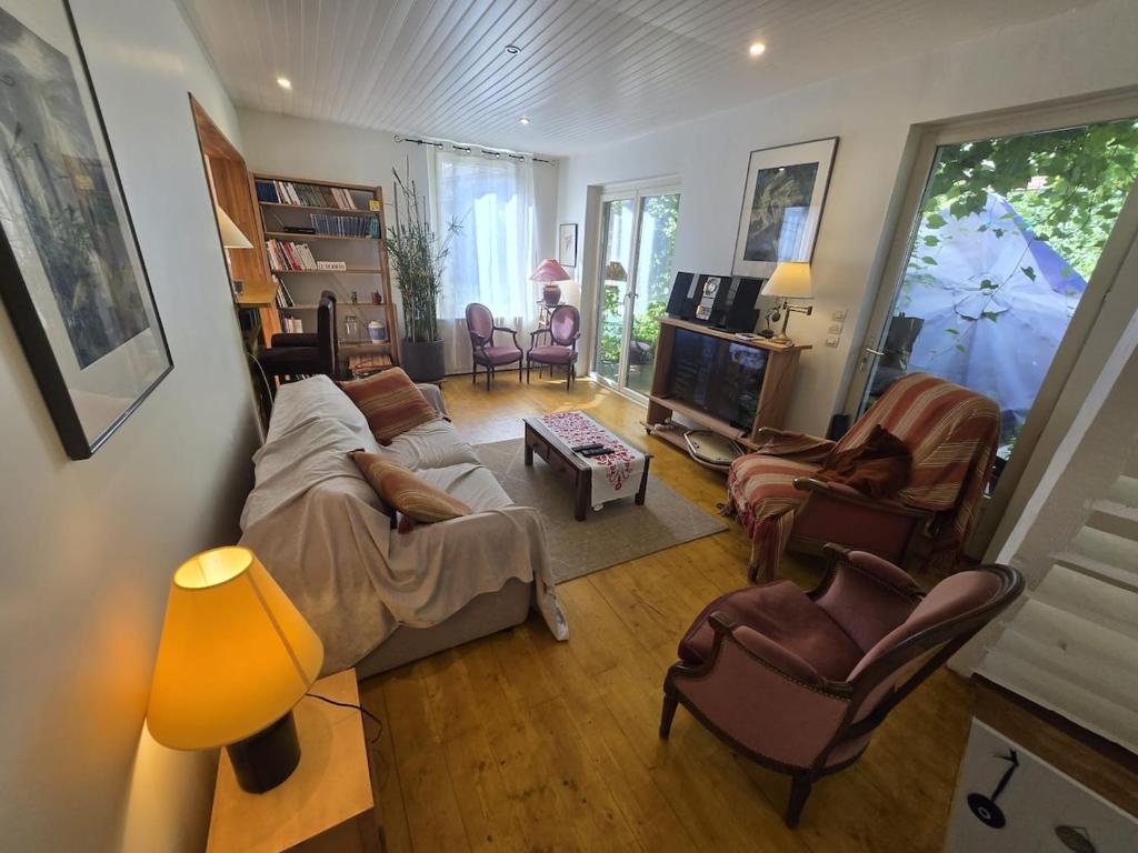 ein Wohnzimmer mit Sofa, Sesseln und Fernseher in der Unterkunft Grande maison calme proche centre terrasse jardin in Besançon