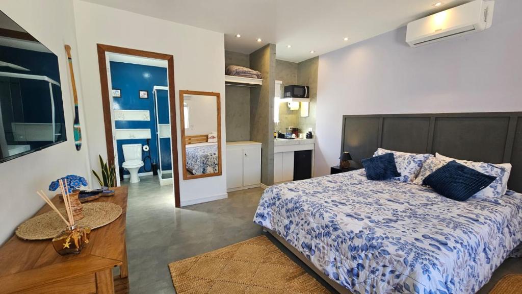 a bedroom with a large bed and a bathroom at ensueños in Búzios