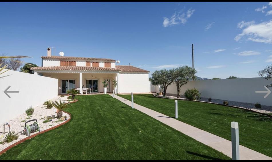 a house with a green lawn in front of it at Casa MILLY in Olbia