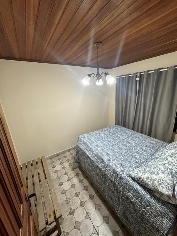 a bedroom with a bed and a wooden ceiling at Casa de campo com piscina em meio à natureza in Campo Magro