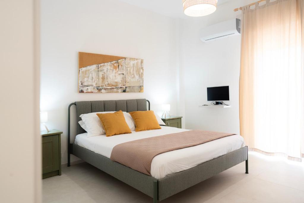 a bedroom with a bed with two orange pillows at Casa Santiago in Agrigento