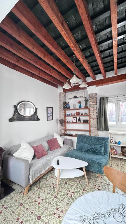 a living room with a couch and a table at El ático de los mosaicos in Cádiz