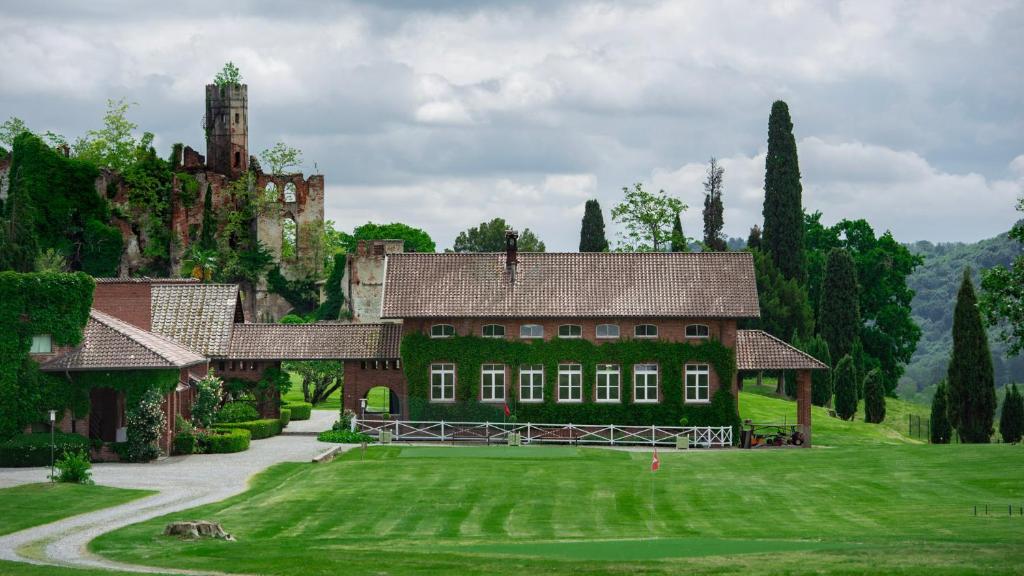 a large house with a green yard and a castle at B&B Tenuta Castello Golf Club in Cerrione