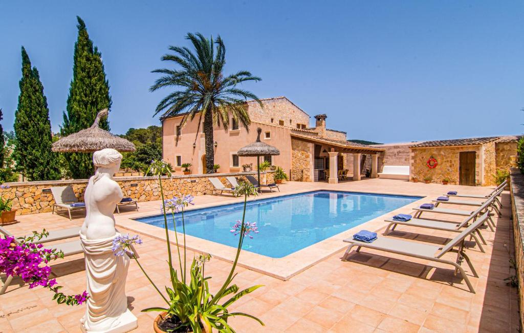 a villa with a swimming pool and a statue at Cas Cuni in Felanitx