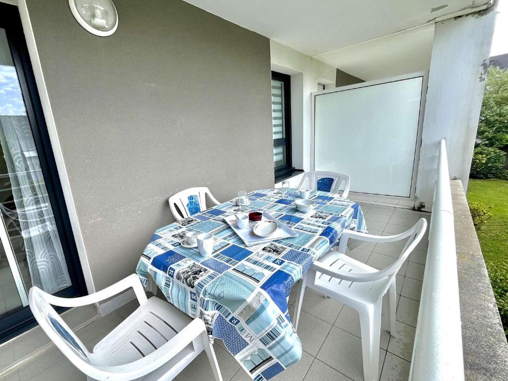 a table and chairs on a balcony with a table and a table and chairs at Appartement moderne 2 pièces avec grand balcon à Étel, proche plage - FR-1-479-166 in Étel