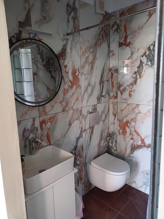 a bathroom with a sink and a toilet and a mirror at LA.KI House in Kavala