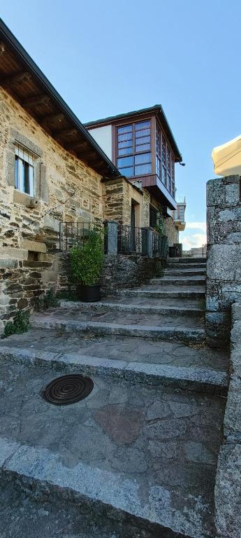 a stone house with a staircase leading up to it at 85 Teclas in Puebla de Sanabria