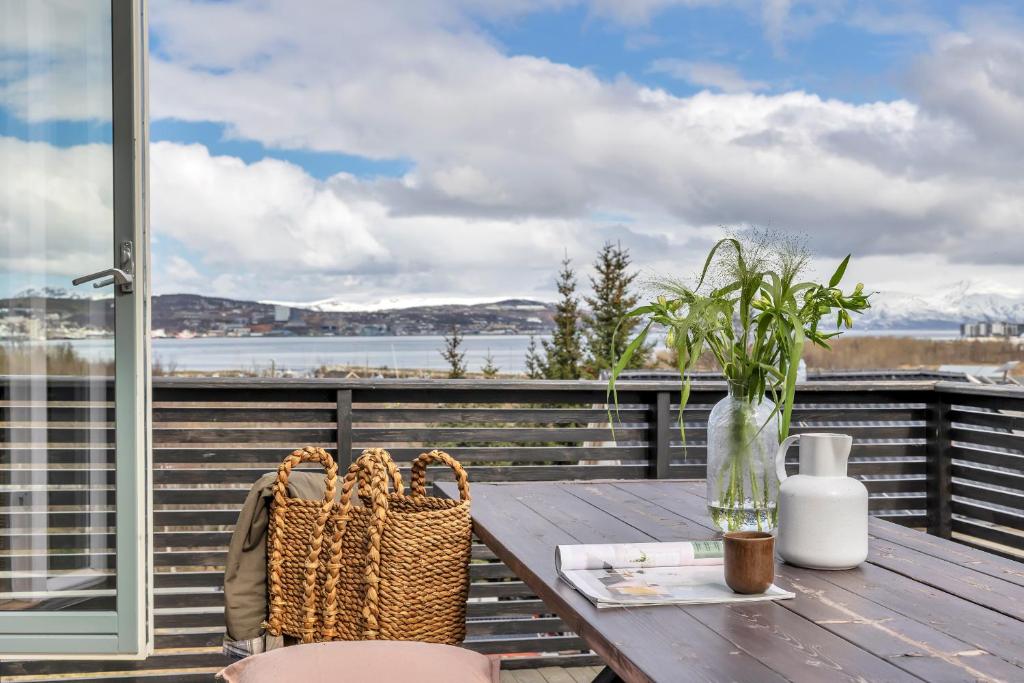 a table with two chairs and a vase on a balcony at Unique Family House Near the Arctic Cathedral in Tromsø