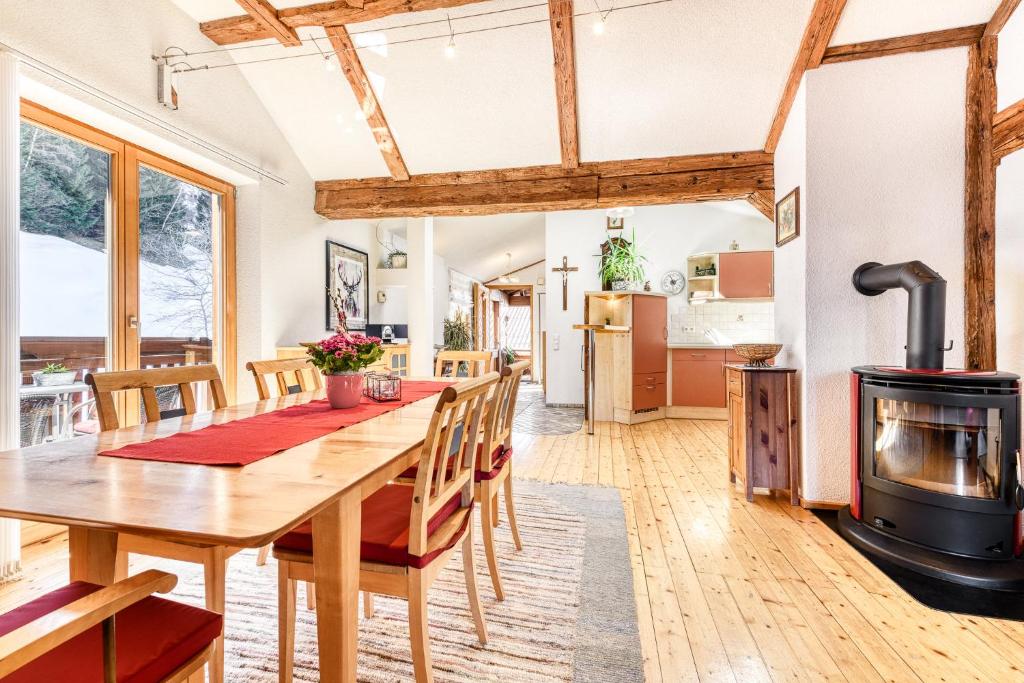 a kitchen and dining room with a wooden table and a wood stove at Chalet Fischer by A-Appartments in Bürserberg