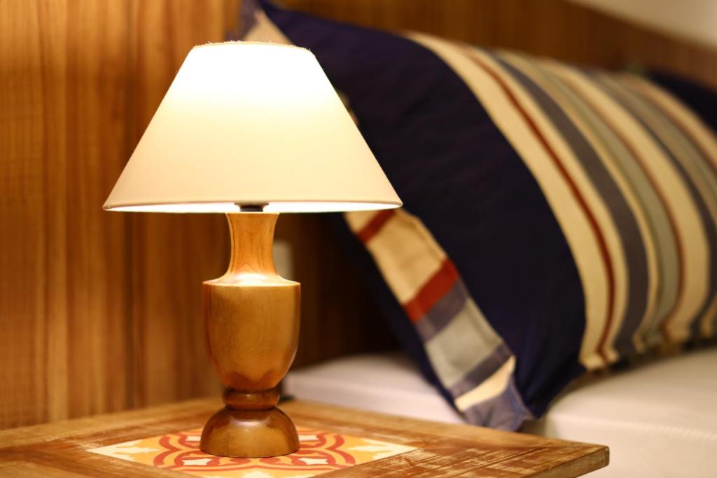 una lampada appoggiata su un tavolo accanto a un letto di In Mare Bali Apto Residencial Resort a Parnamirim