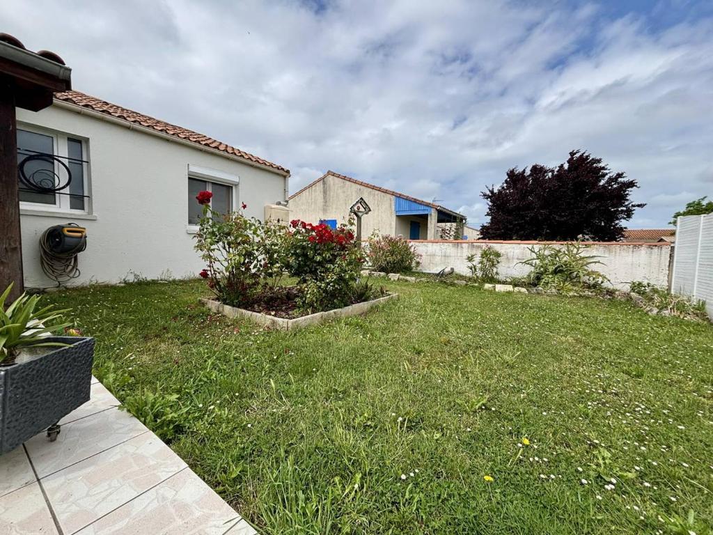 une cour avec une maison blanche et une clôture dans l'établissement Maison 3 pièces au cœur de Saint-Pierre d’Oléron, 6 couchages - FR-1-246A-359, à Saint-Pierre-dʼOléron