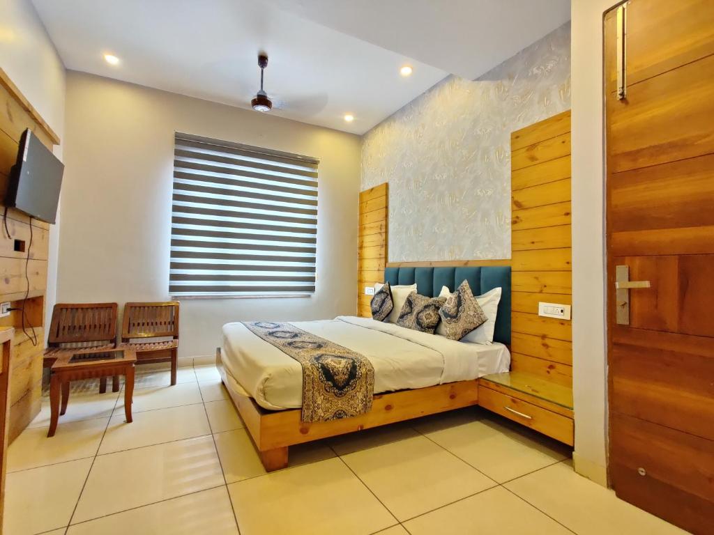 a bedroom with a king sized bed and a window at Hotel Golden Heaven Inn, Amritsar-Near Golden Temple in Amritsar