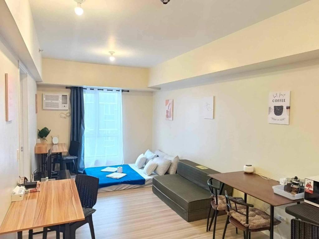 una sala de estar con un sofá y una mesa en Avida Riala at Cebu IT Park Spacious 1 Bedroom with Fast WiFi Smart TV For 6, en Cebú