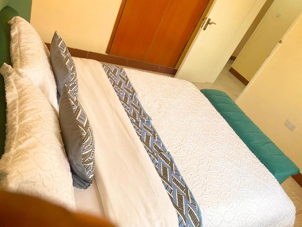 a white bed with two pillows on top of it at Lulu's Origo Jinja in Iganga