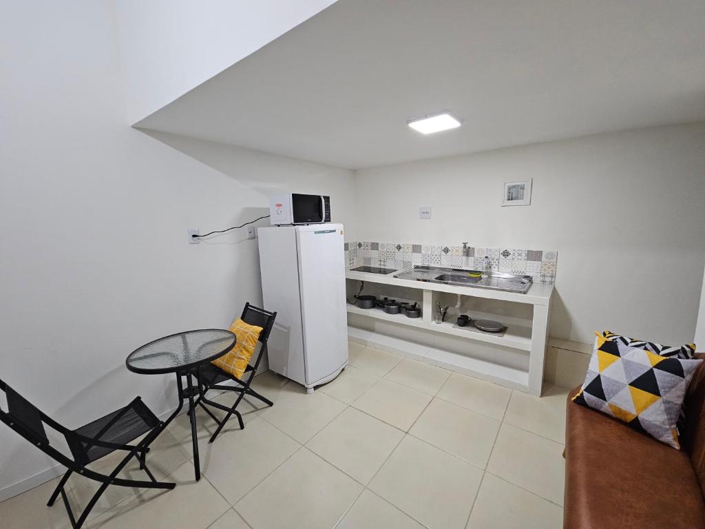 a kitchen with a refrigerator and a table and chairs at Loft Nicolau Garcia in São José