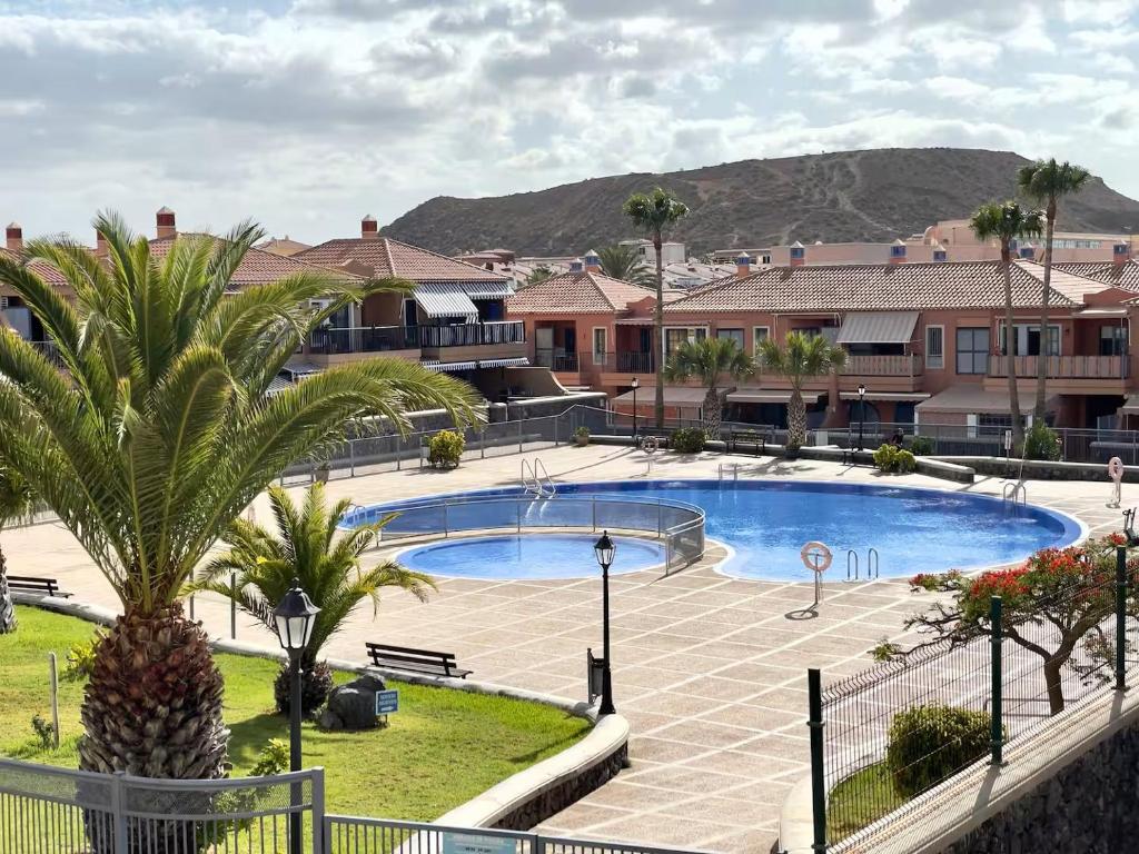 una piscina con una palma accanto a un edificio di Atlantico 43 ad Arona