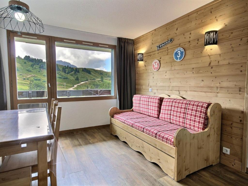 une chambre avec un canapé, une table et une fenêtre dans l'établissement Appartement rénové avec balcon, au pied des pistes et proche commerces – Belle Plagne - FR-1-455-35, à Belle Plagne