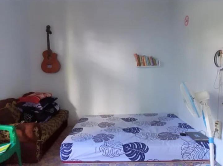 a bedroom with a bed and a guitar on the wall at Infinity in Seganteng