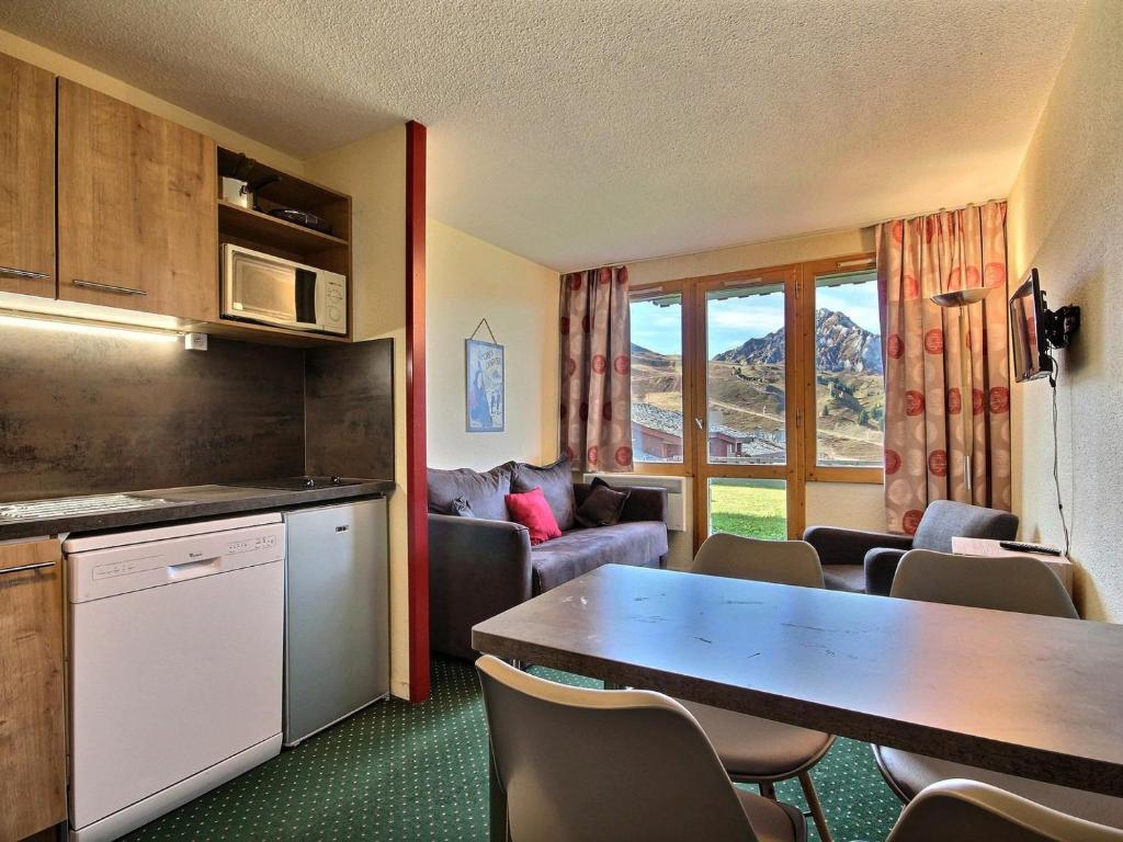 une cuisine et un salon avec une table et des chaises dans l'établissement Studio accessible PMR au pied des pistes avec terrasse - FR-1-455-24, à Belle Plagne