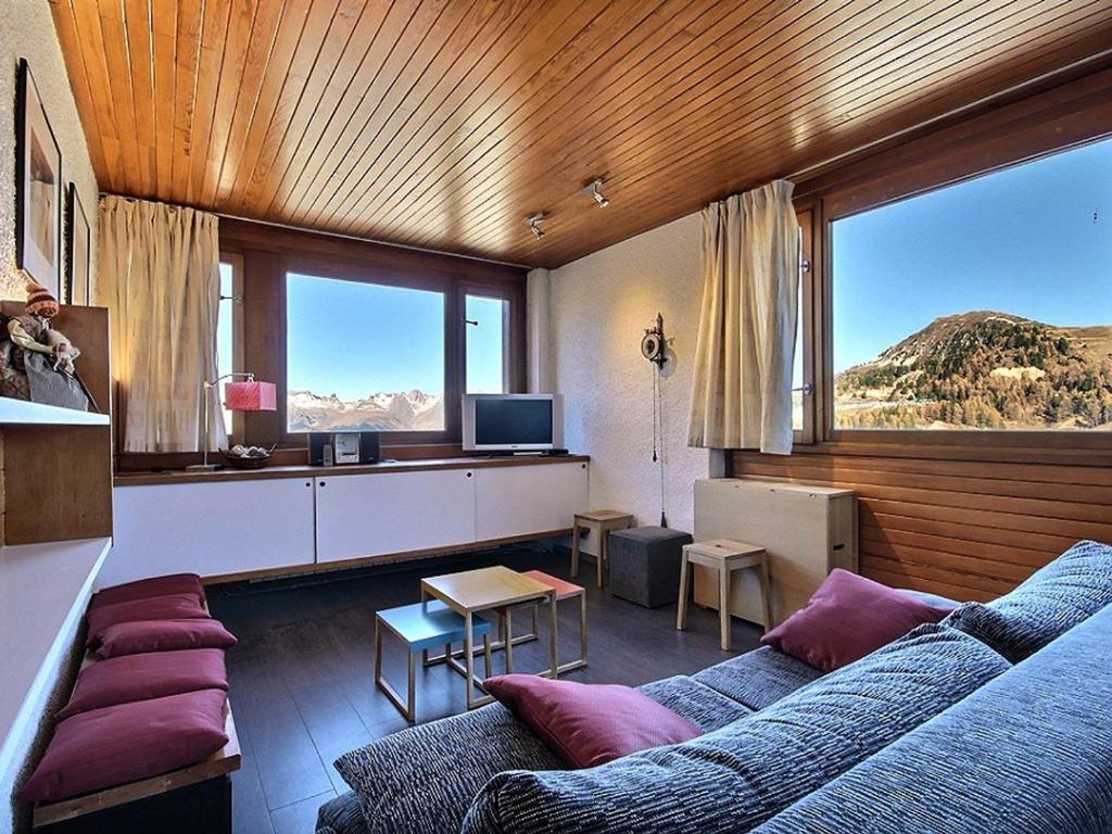 un salon avec un canapé et une grande fenêtre dans l'établissement Appartement cosy au pied des pistes avec balcon et équipements modernes - FR-1-455-61, à La Plagne