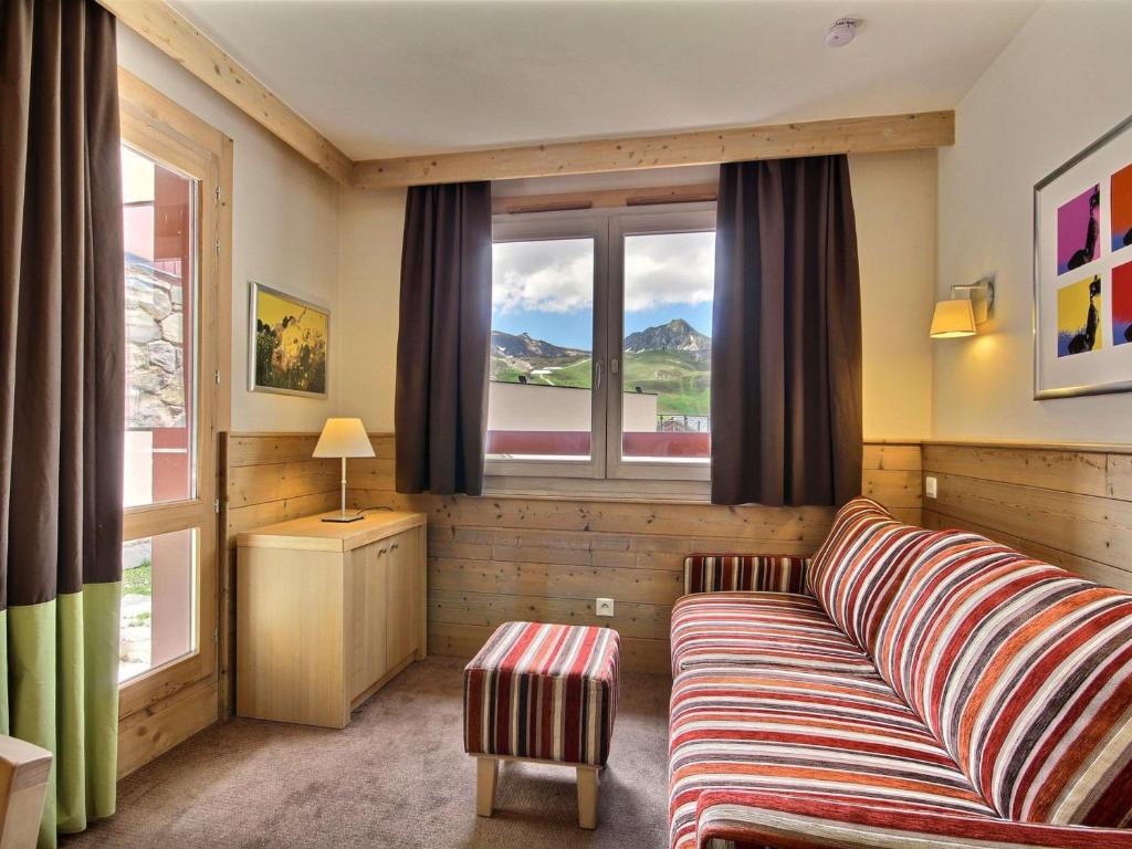 un salon avec un canapé et une fenêtre dans l'établissement Studio cabine chaleureux, 4 pers, balcon, vue montagnes, près des pistes, spa - FR-1-455-184, à La Plagne Tarentaise