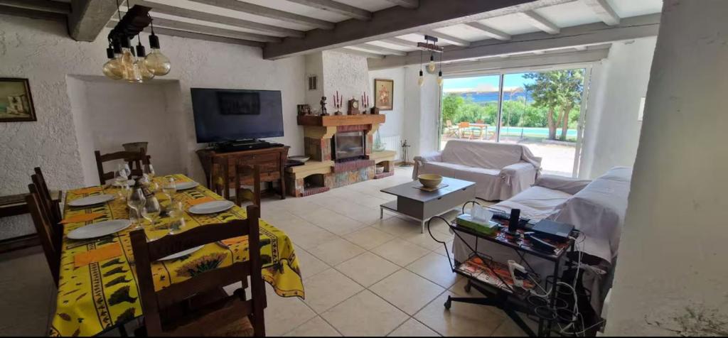un salon avec un canapé, une table et une télévision dans l'établissement F4 house with Wifi and private pool in Vidauban, à Vidauban