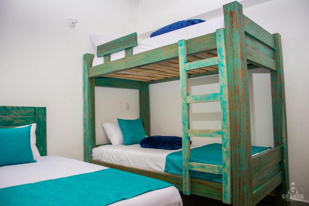 two bunk beds in a room with a ladder at Hotel Madre Laura Jericó in Jericó