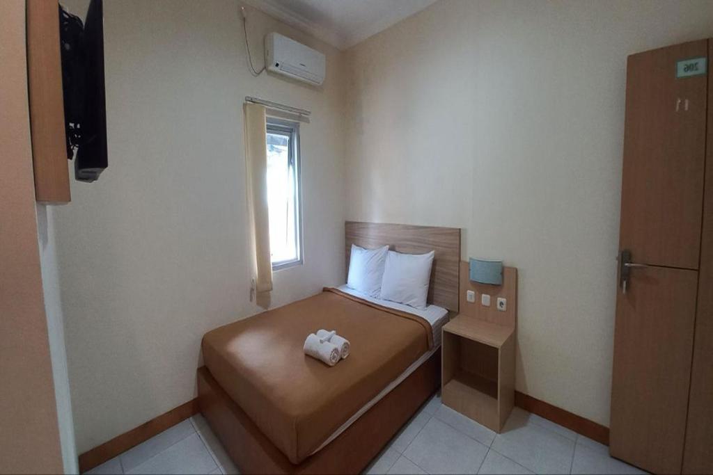 a small bedroom with a bed and a window at OYO 94715 Homestay Kembar Syariah in Sragen