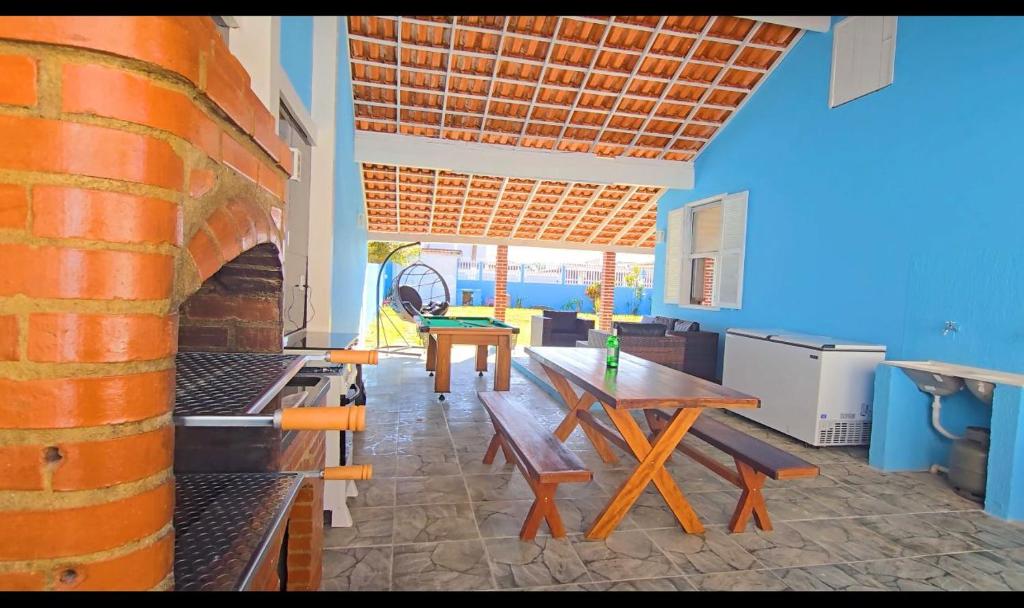 a room with benches and tables in a building at Casa Encanto da Vila in Saquarema
