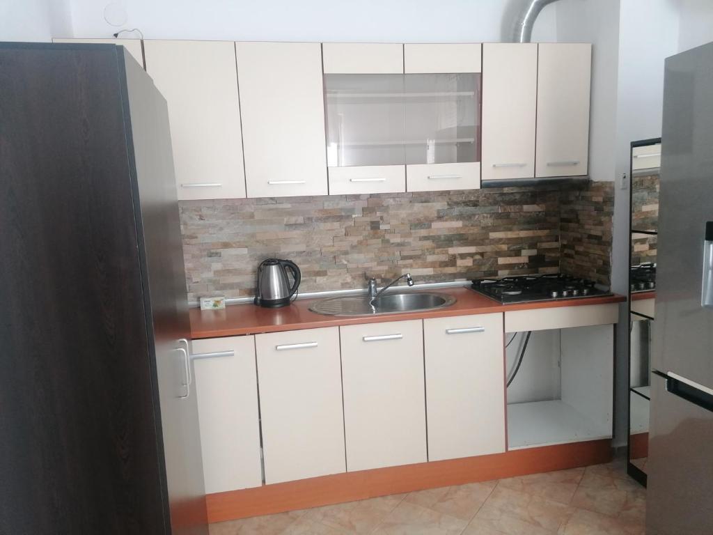 a kitchen with white cabinets and a sink at Guest House Plovdiv in Plovdiv