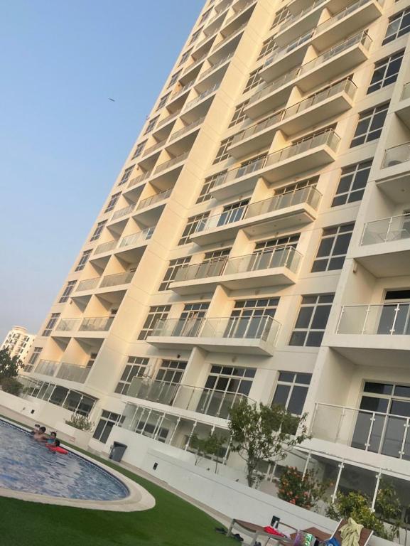 a large building with a swimming pool in front of it at Bahrain Amwaj in Amwaj Island