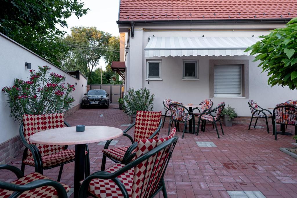 a patio with chairs and a table and a table and chairs at Kollar D Guest House - Prenoćište ROOMS in Subotica