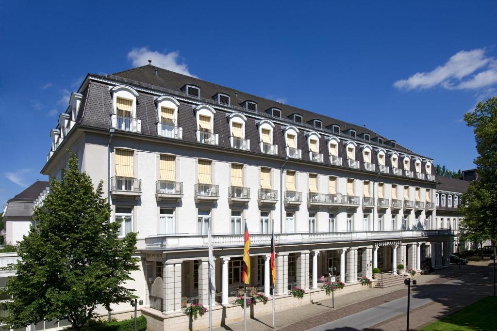 un gran edificio blanco con un árbol delante en Steigenberger Hotel & Spa Bad Pyrmont, en Bad Pyrmont