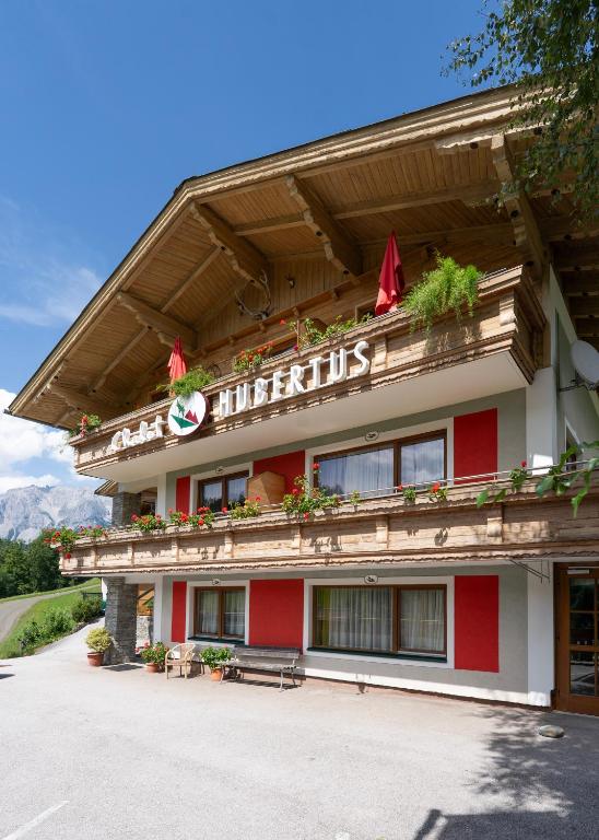 a red and white building with a sign on it at Chalet Ferienhaus Hubertus in Schladming