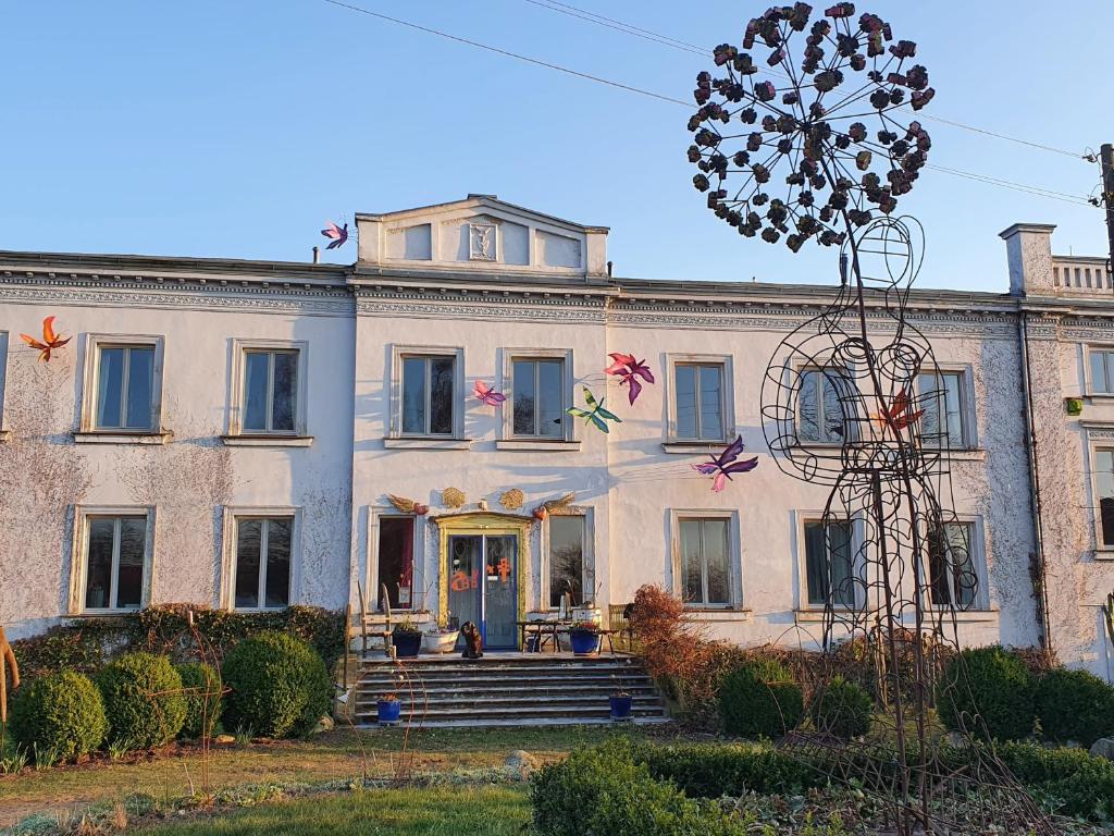 a large white house with a front porch at Kunstgut Patapaya in Neukalen