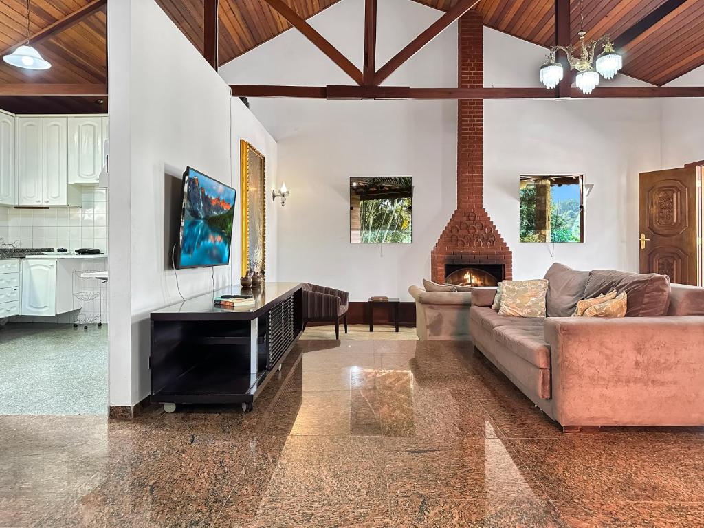 a living room with a couch and a fireplace at Refúgio Natureza Piscina Sala de Jogos Lazer in Campo Limpo Paulista