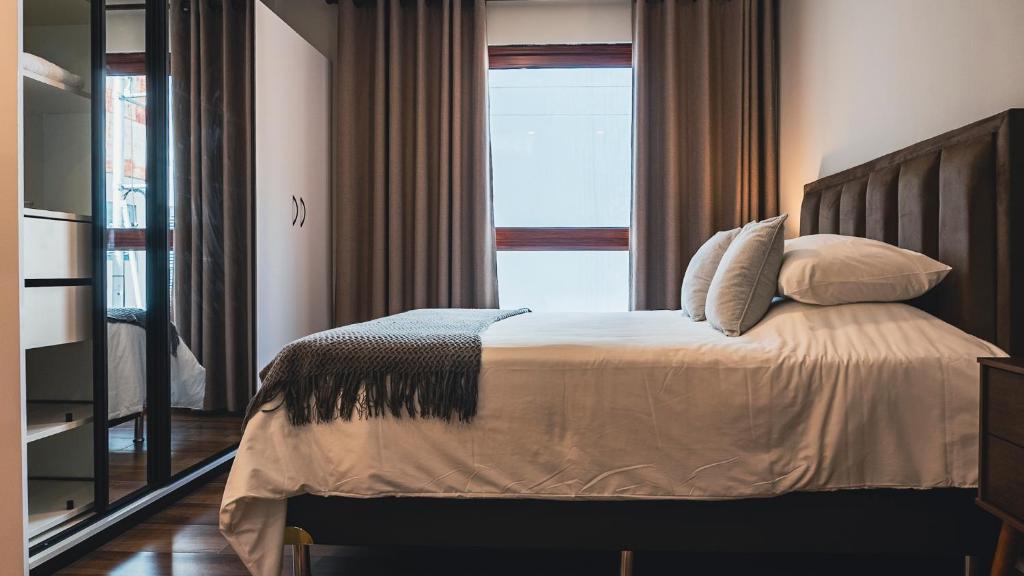 a bedroom with a bed with pillows and a window at Elegant Suite in Santa Cruz de la Sierra