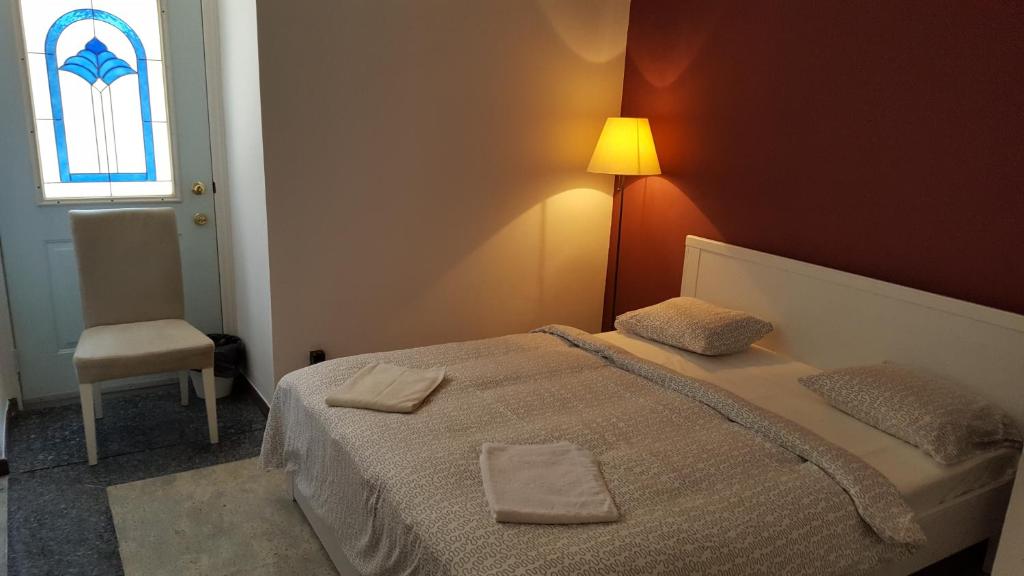 a bedroom with a bed with a lamp and a chair at Cozy Central Retreat in Budapest