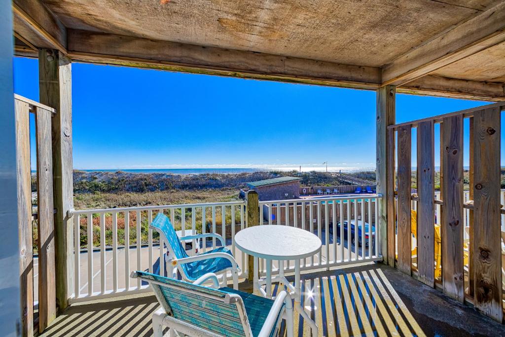 a balcony with two chairs and a table on it at Gnarly Wave 351 #103DS-H in Hatteras