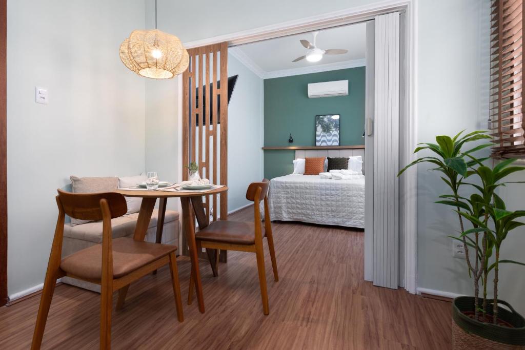 a dining room with a table and a bedroom at Studio em Botafogo a 150m do metrô in Rio de Janeiro