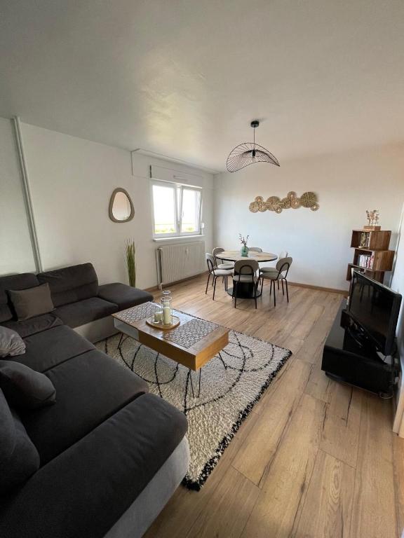 a living room with a couch and a table at Chez Mégane & Anthony à Strasbourg in Entzheim