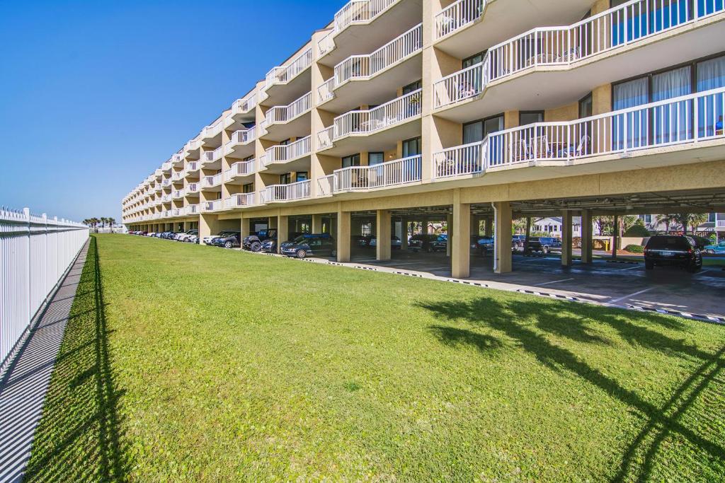 a large apartment building with a lawn in front of it at Charleston Oceanfront Villas 311 in Folly Beach