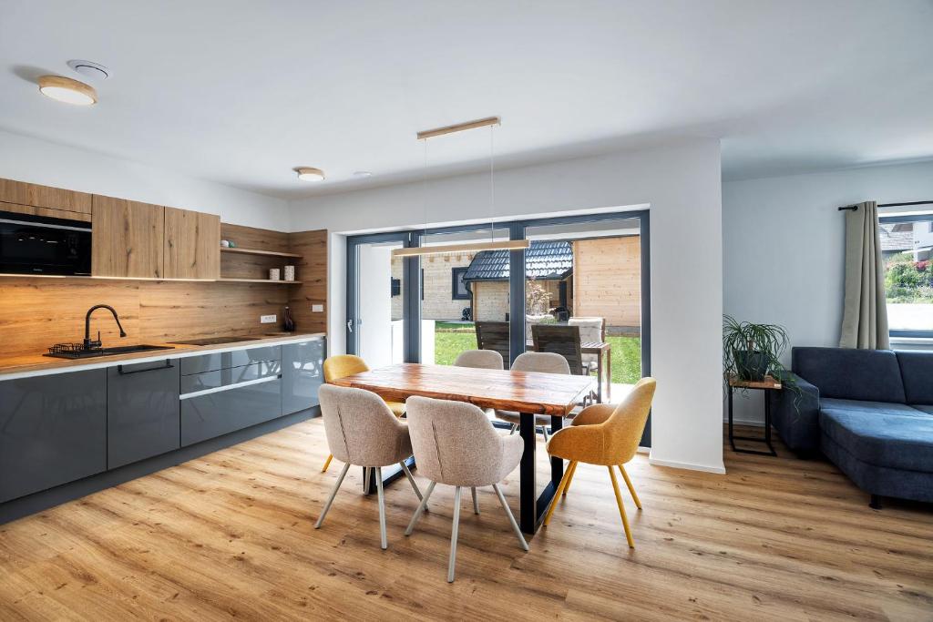 a kitchen and dining room with a table and chairs at Family and Friends Apartments Bled in Spodnje Gorje