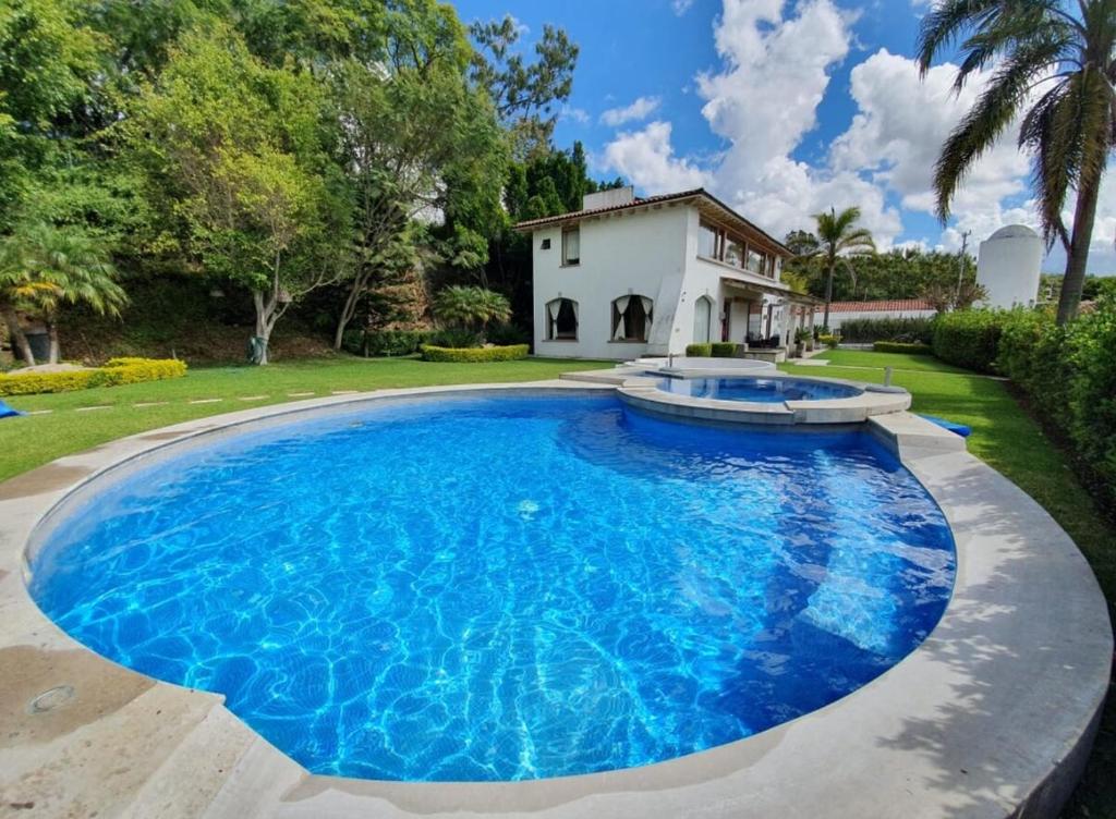 een groot zwembad met blauw water voor een huis bij Casa Vista Hermosa in Tonatico
