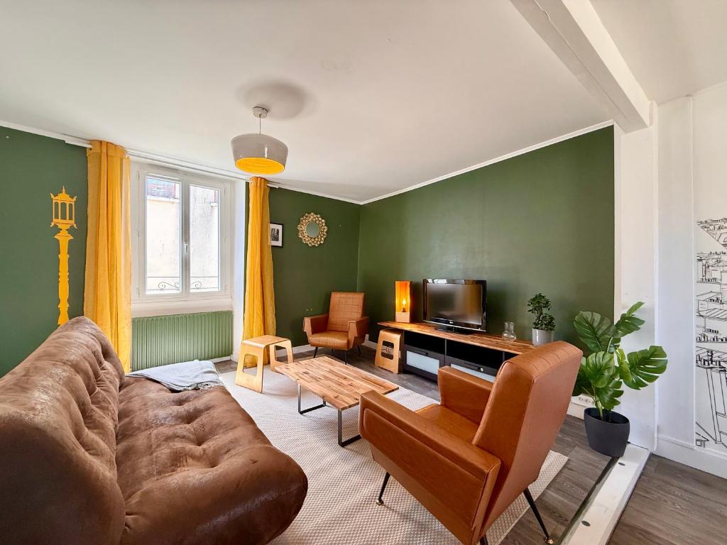 a living room with a couch and a tv at 9 couchages - Proche Disneyland Paris in Ferrières-en-Brie