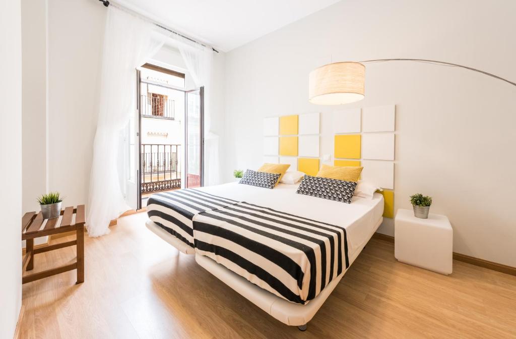 a white bedroom with a bed and a window at Smartr Madrid Chueca in Madrid