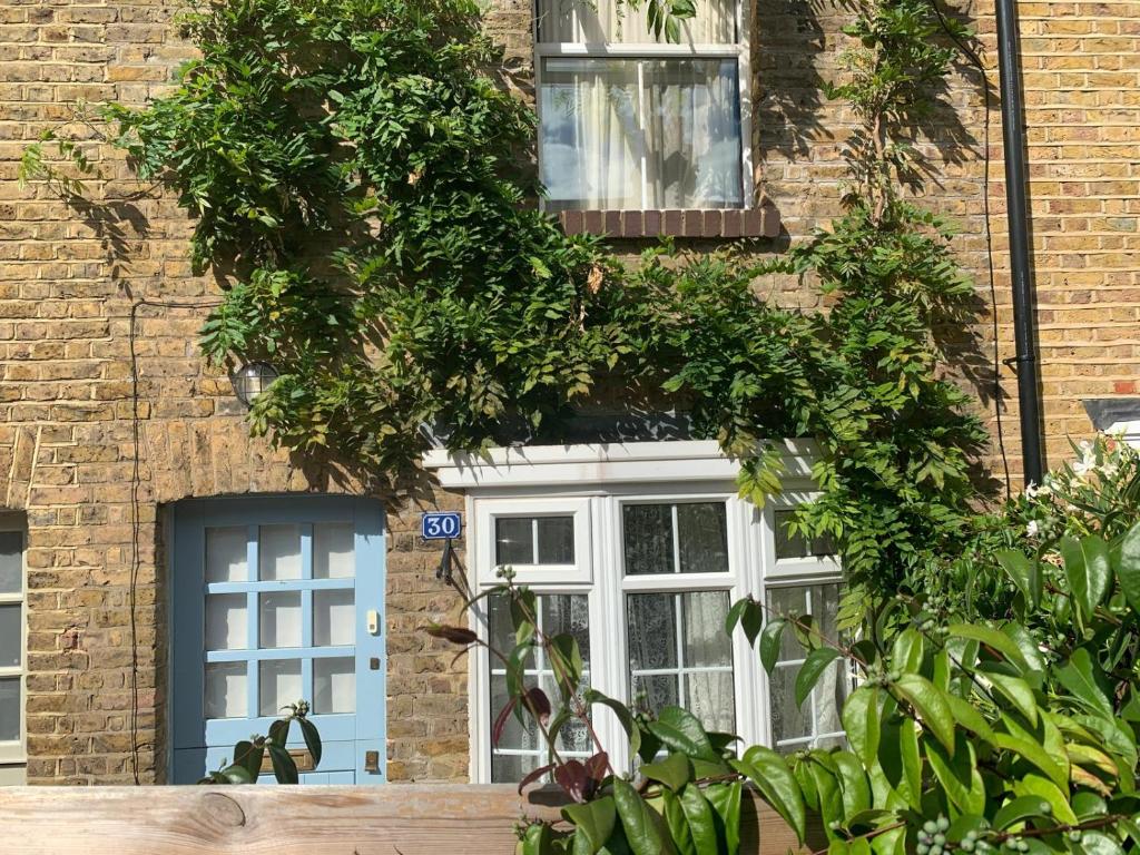 Una casa con una puerta azul y árboles delante de ella. en Victorian House in the heart of Richmond, en Richmond upon Thames